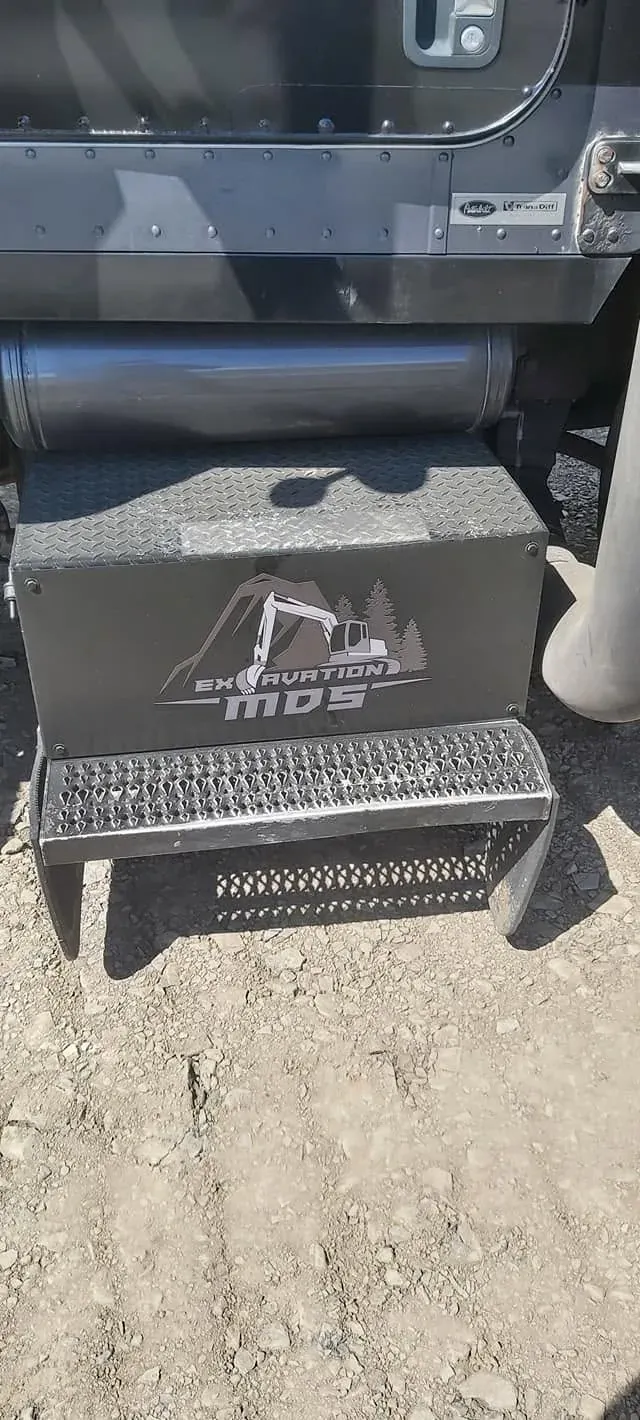 Logo d’Excavation MDS peint sur le marchepied d’acier du camion Peterbilt