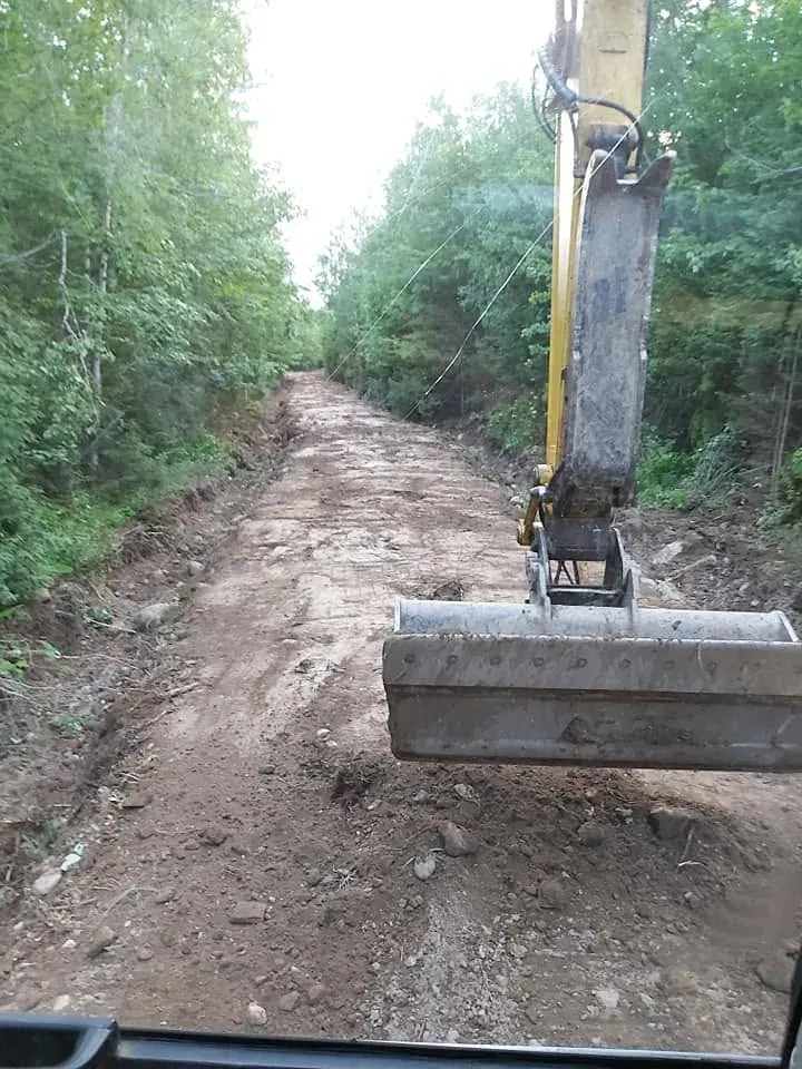 Pelle qui trace un chemin en forêt, vue depuis la cabine